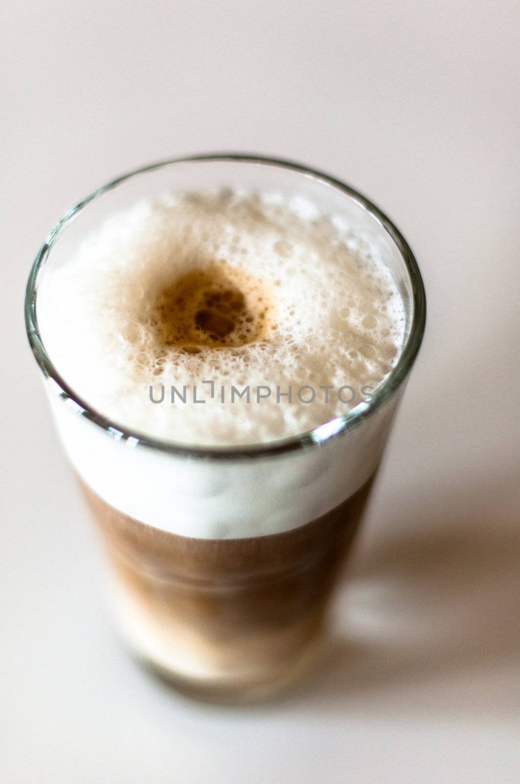 Coffee latte in a tall glass on white background shallow depth of field