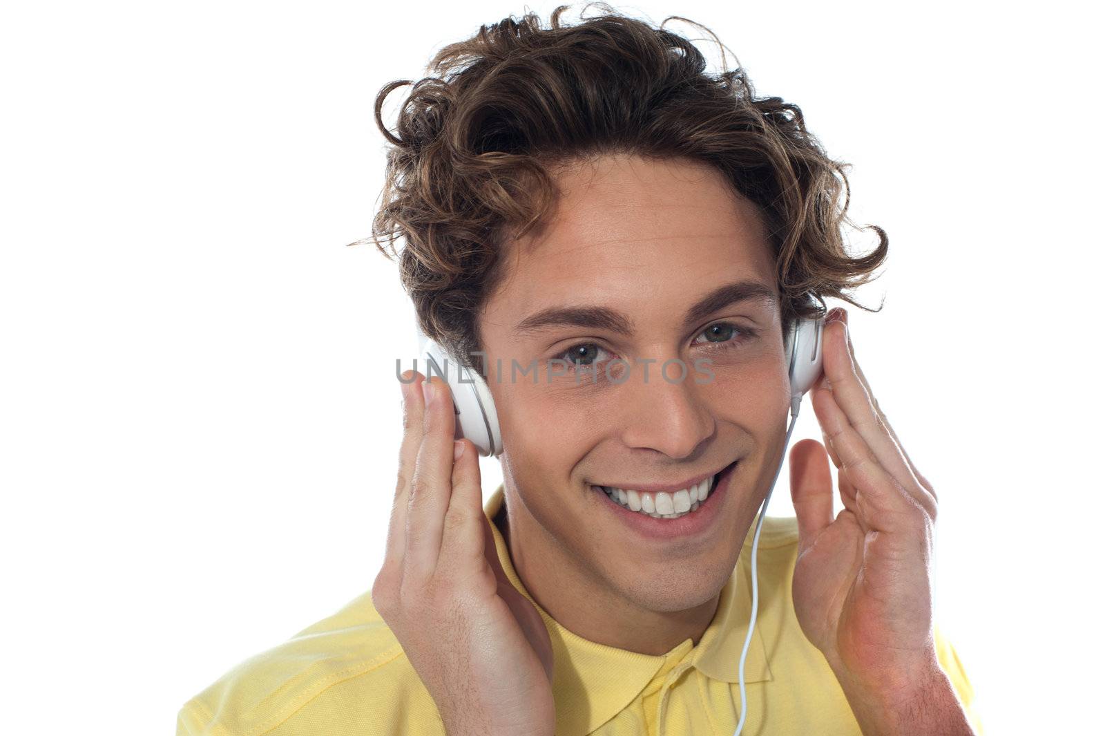 Casual young man listening music with headphones, isolated on white background