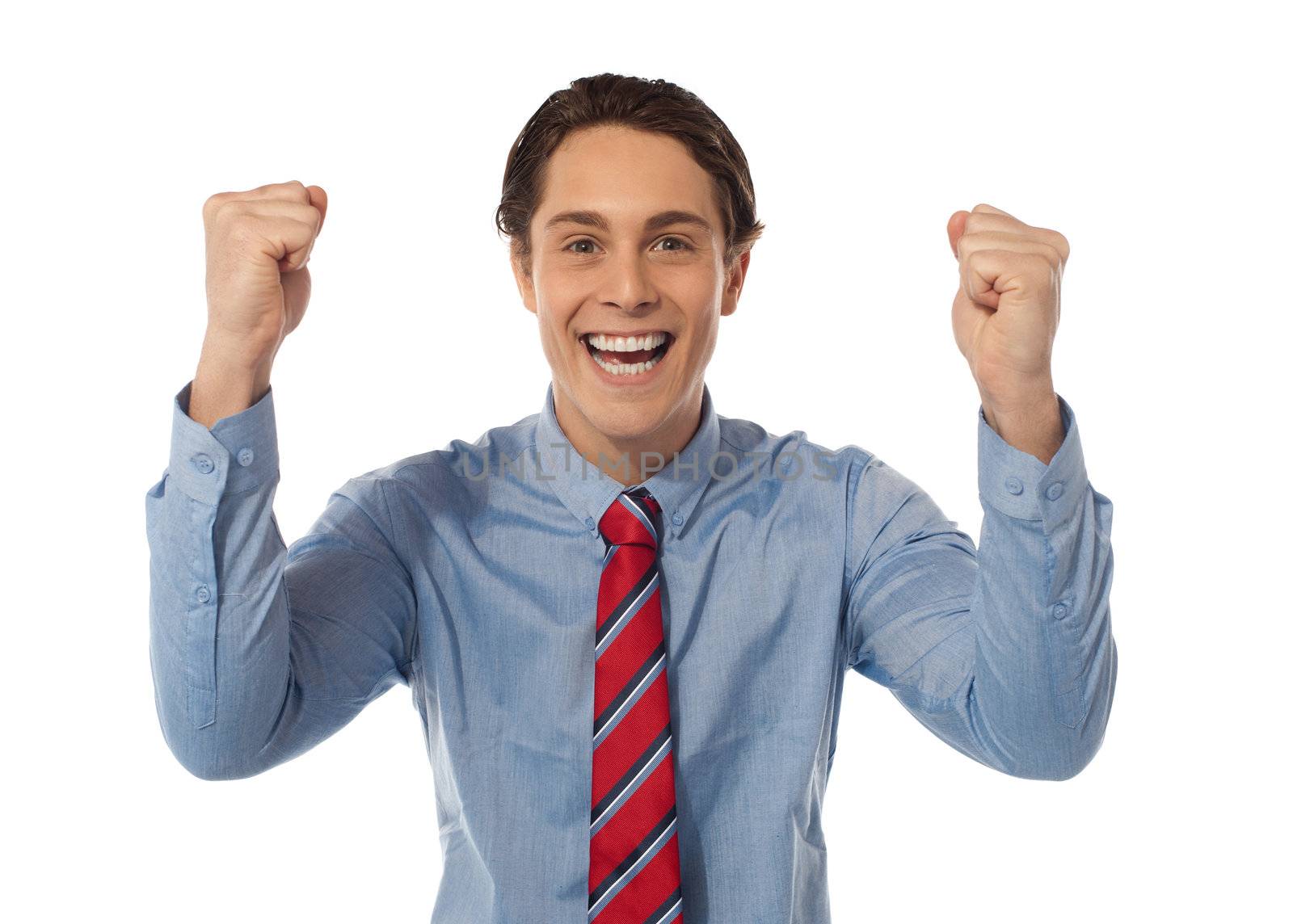 Portrait of confident young businessman celebrating success with arms up