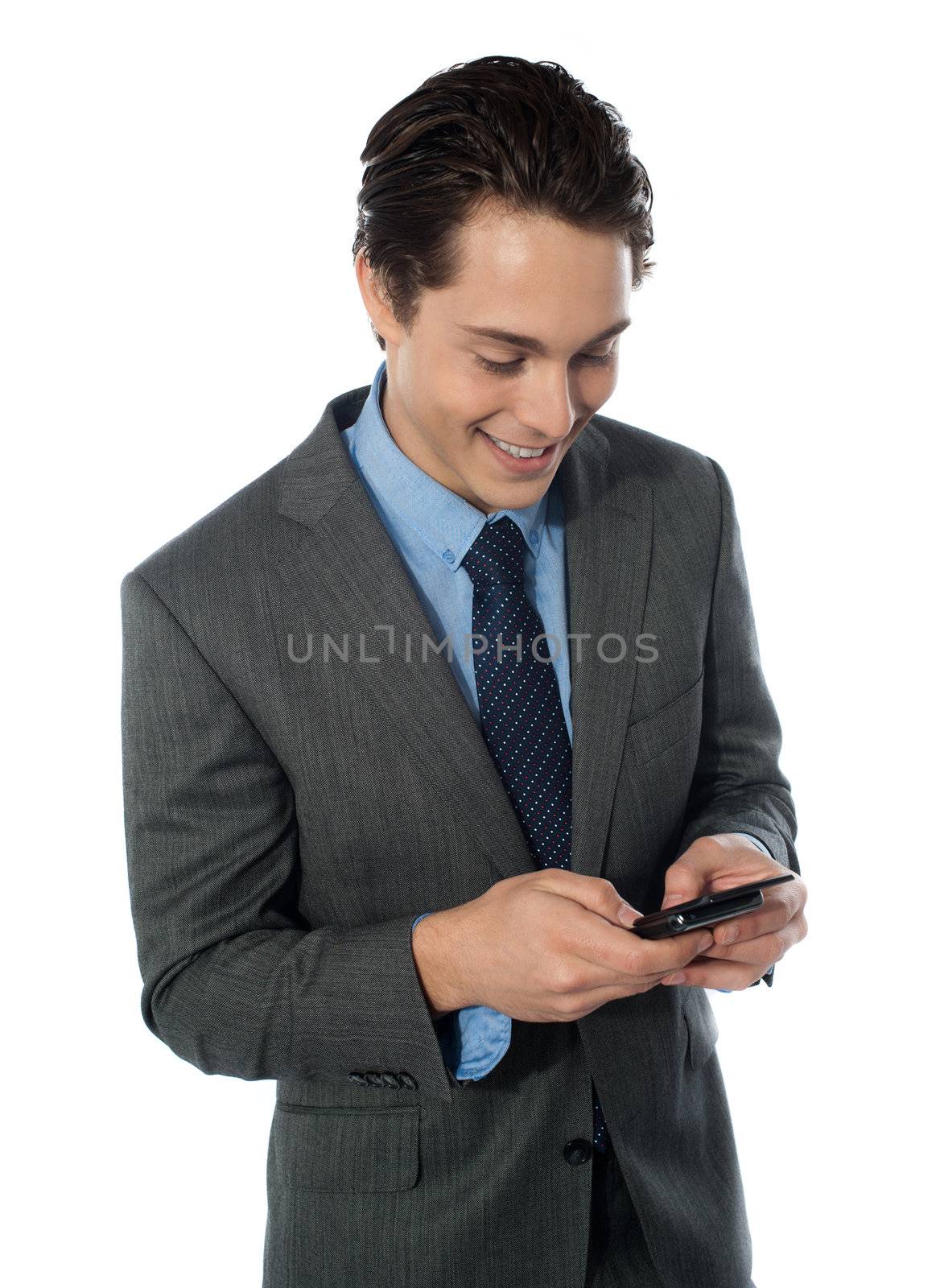 Happy businessman using a mobile phone by stockyimages