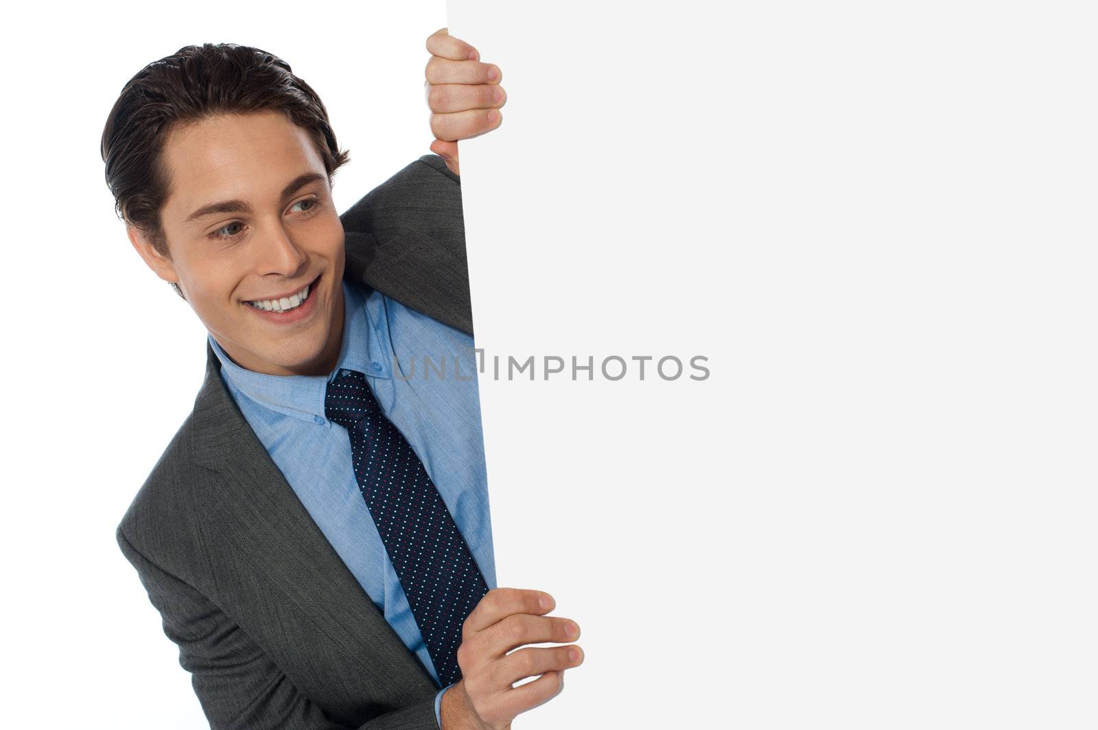 Businessman looking around the corner isolated on white background