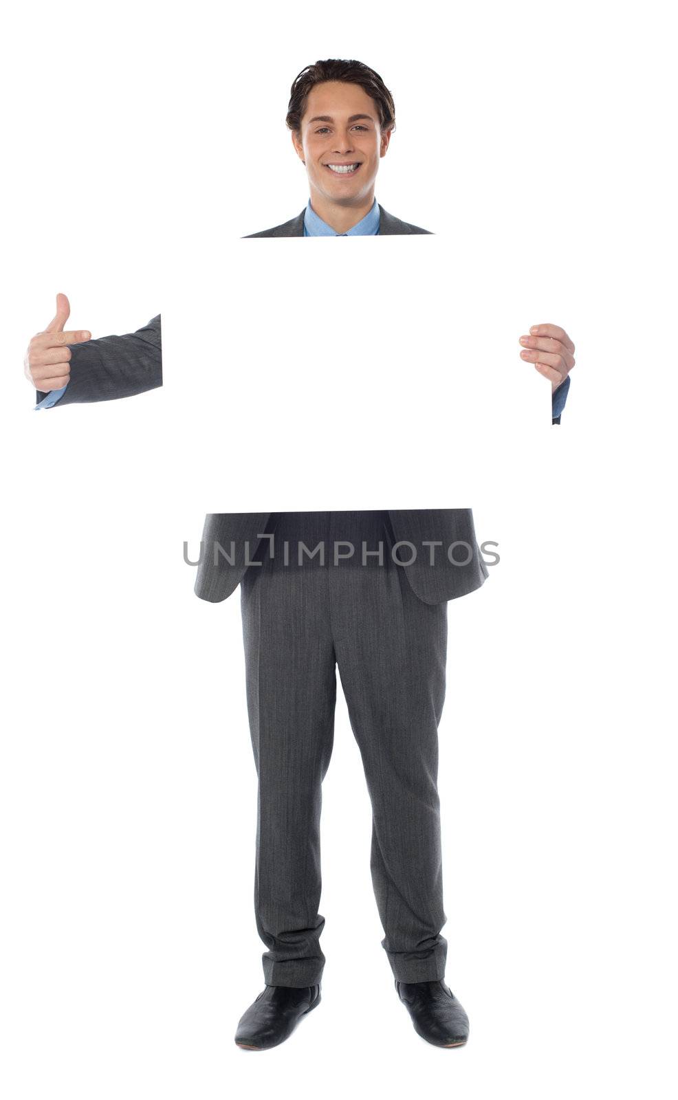 Business professional pointing towards an empty billboard, smiling at camera