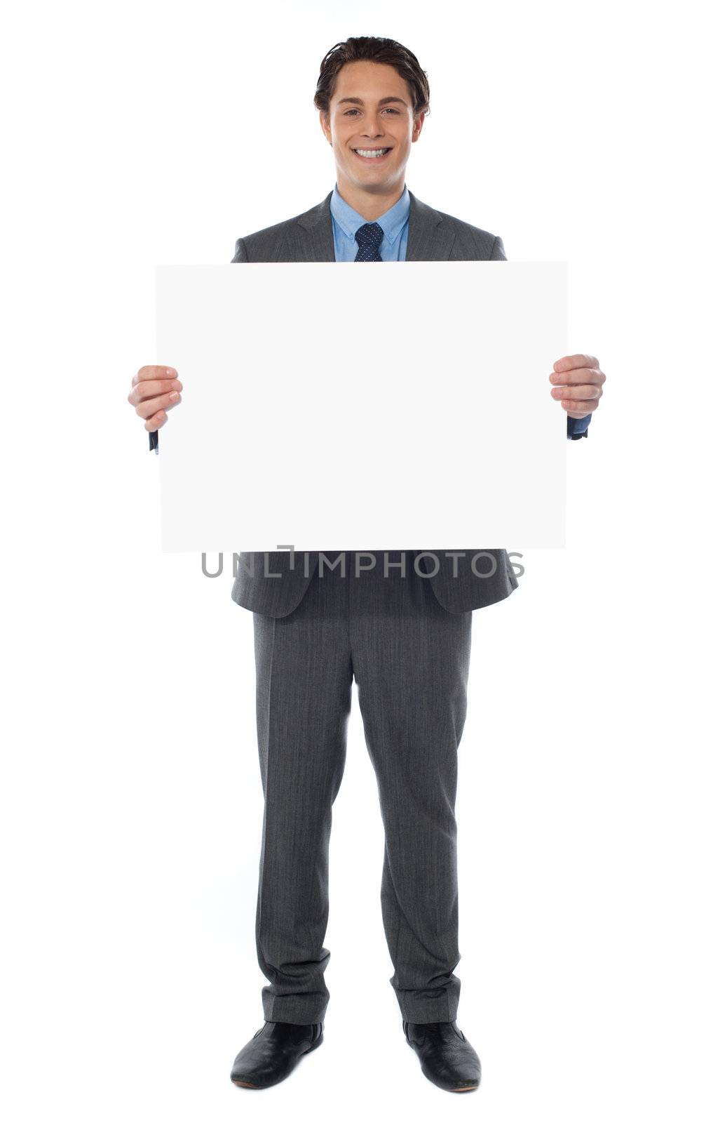 Young businessman holds the blank billboard, full-length view