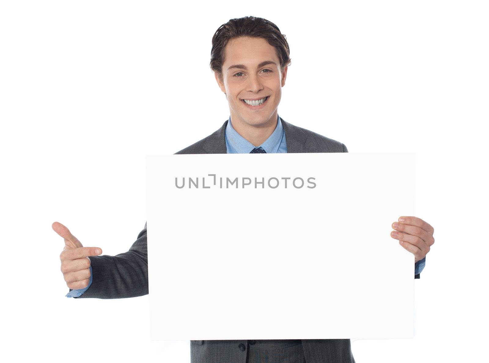 Male executive pointing towards blank billboard by stockyimages