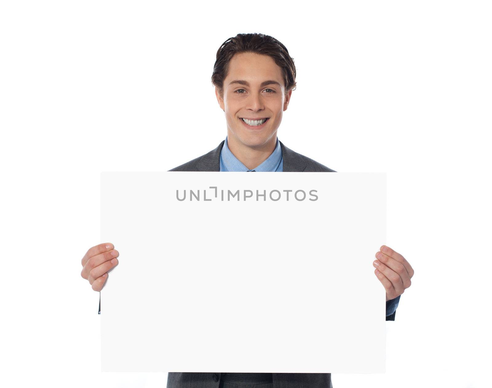 Portrait of a happy businessman showing an emty billboard against white background