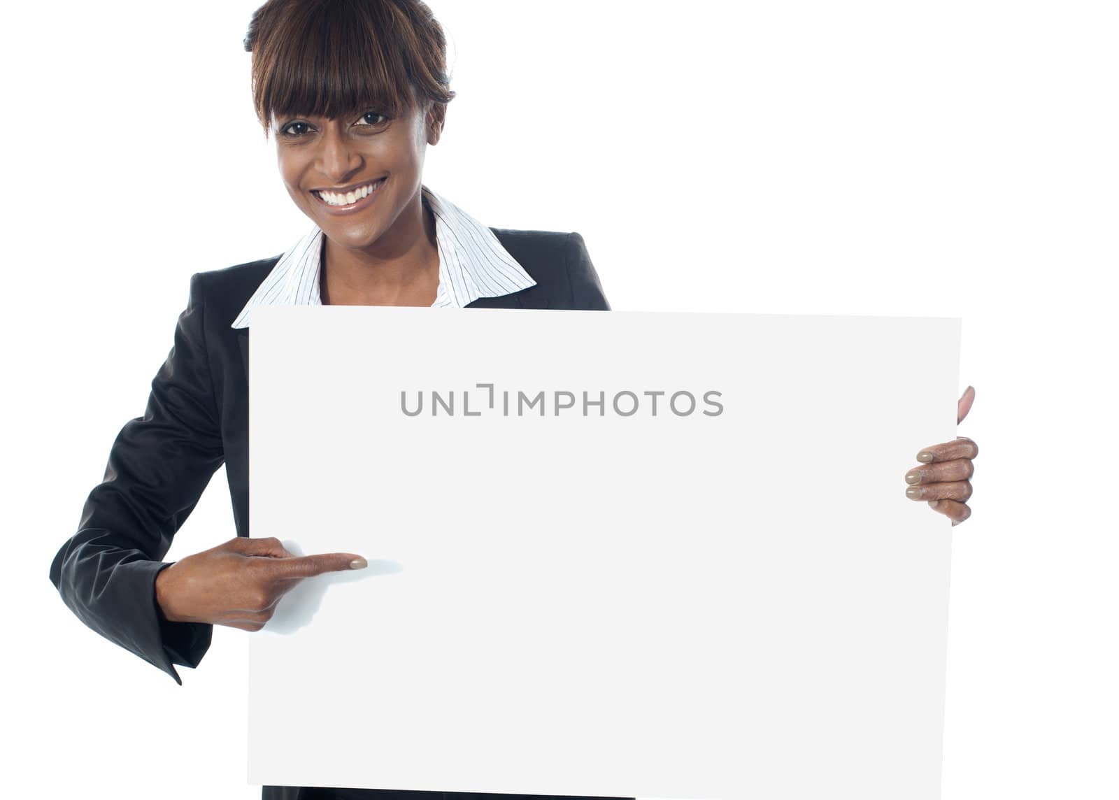 Corporate female executive pointing towards blank banner and smiling at camera