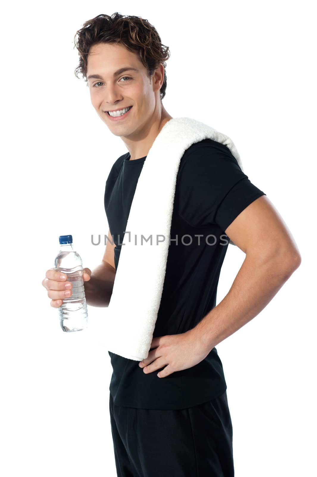 Confident young sporty guy looking at you as he poses with water bottle