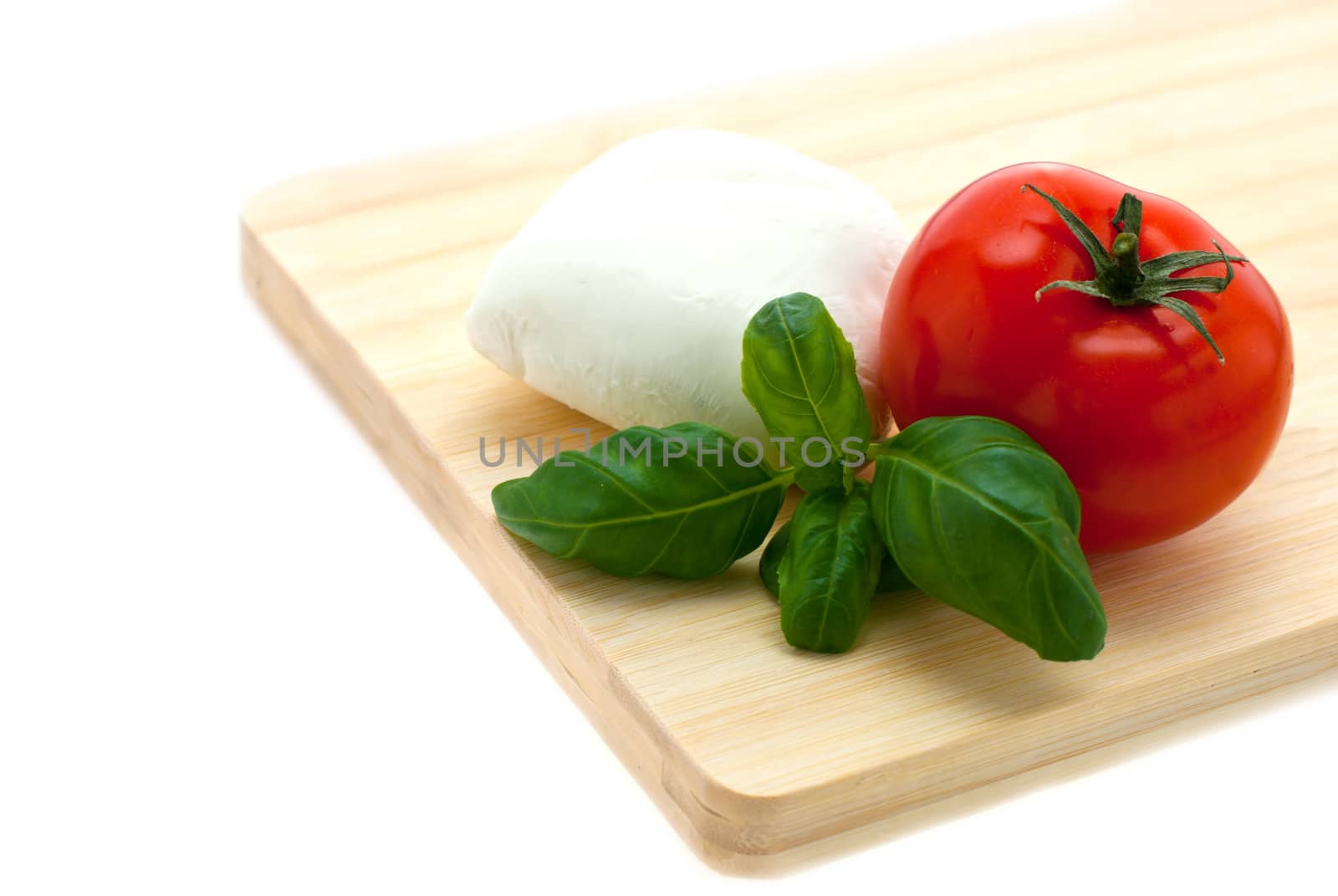 mozzarella, basil, tomatoes lying on the board