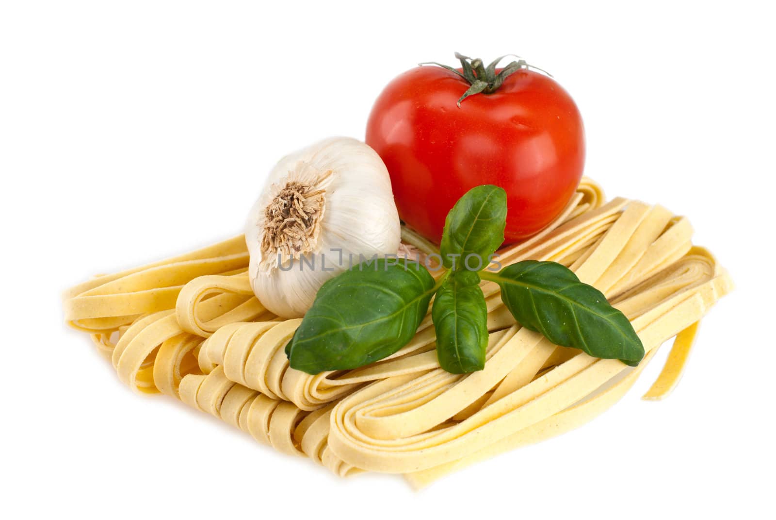 Spaghetti, garlic, tomato, basil shot on a white background.