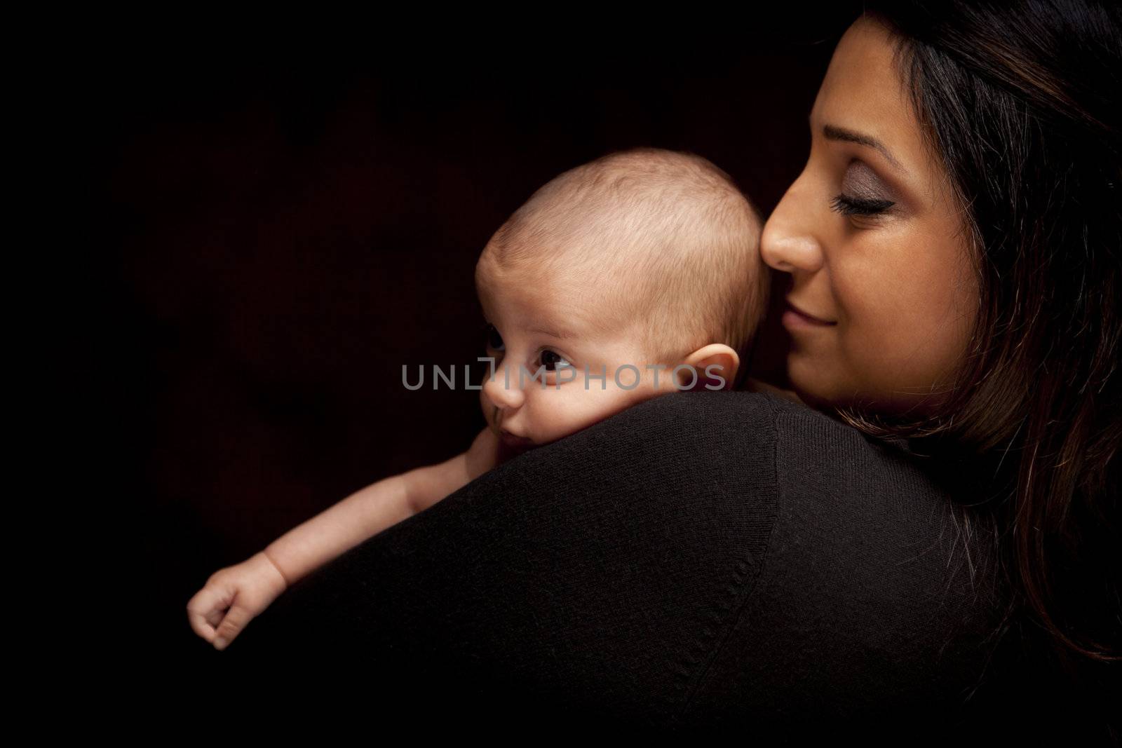 Young Attractive Ethnic Woman Holding Her Newborn Baby Under Dramatic Lighting.