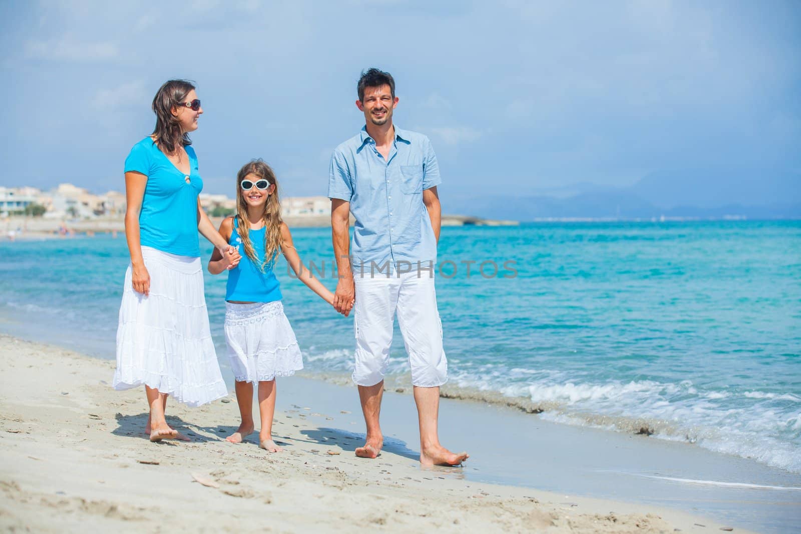 Family of three having fun on tropical beach