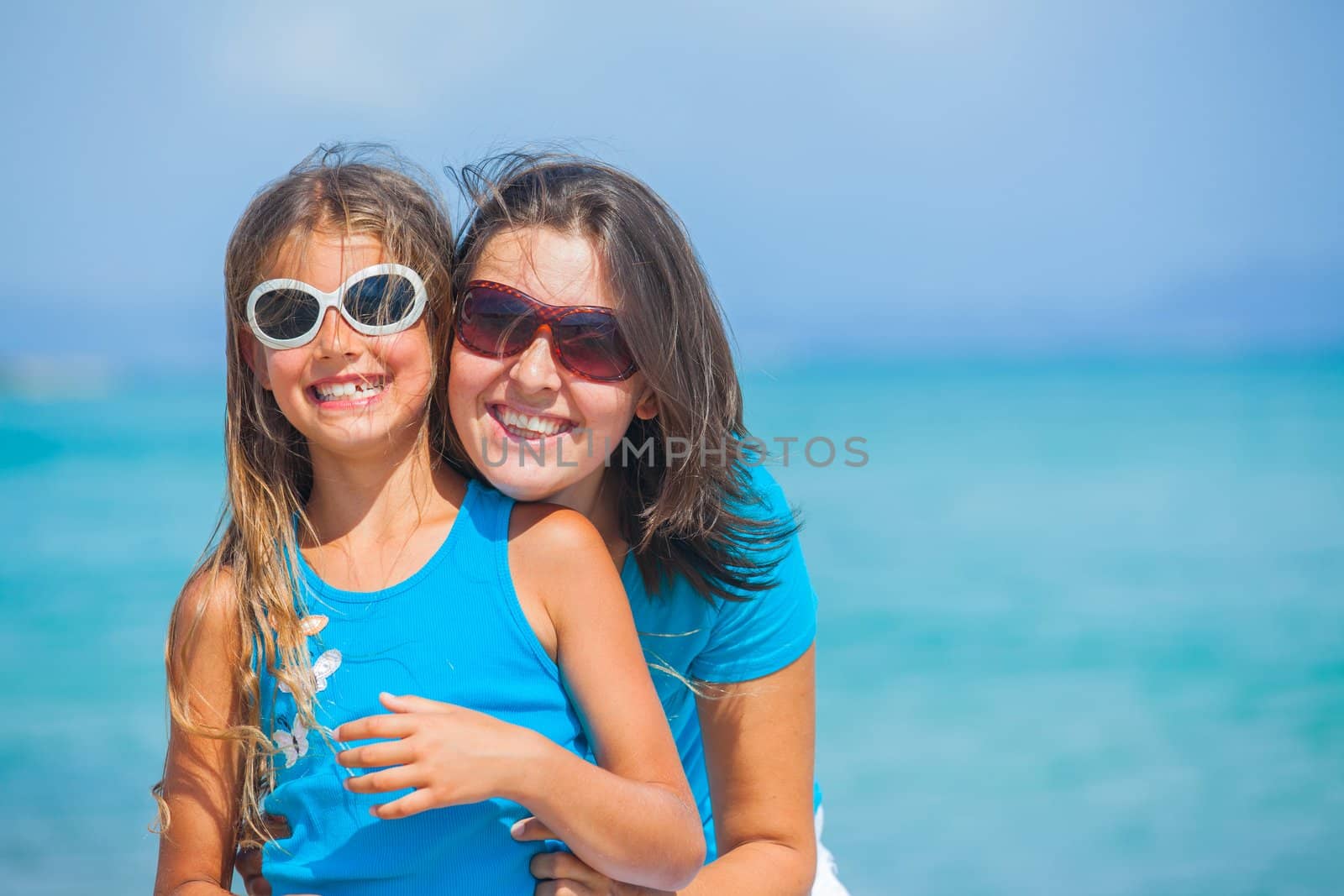 Mother and her daughter having fun on beach by maxoliki