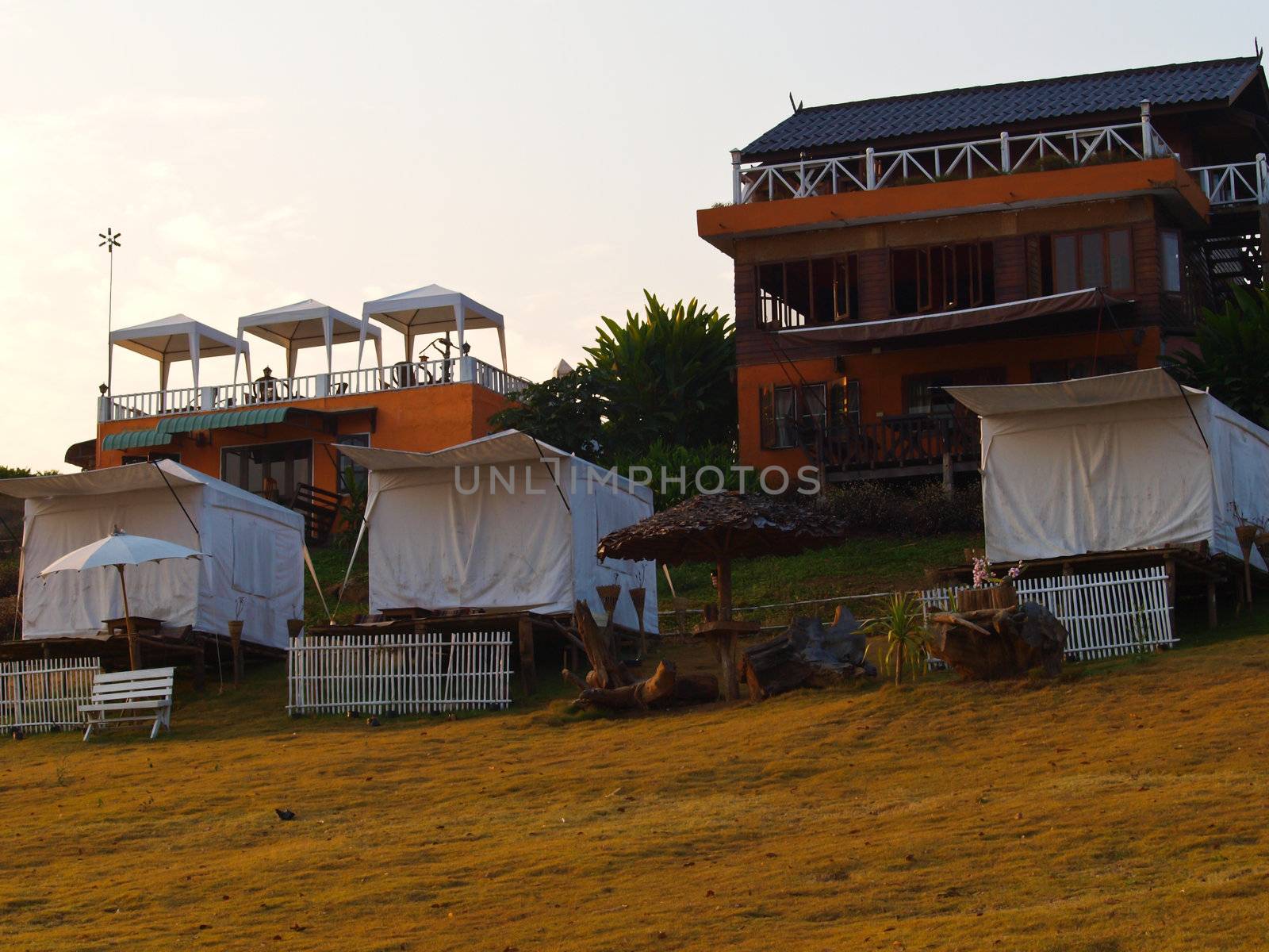 White tents and resort building in Pai, Mae Hong Son and meadow field in Sunrise.