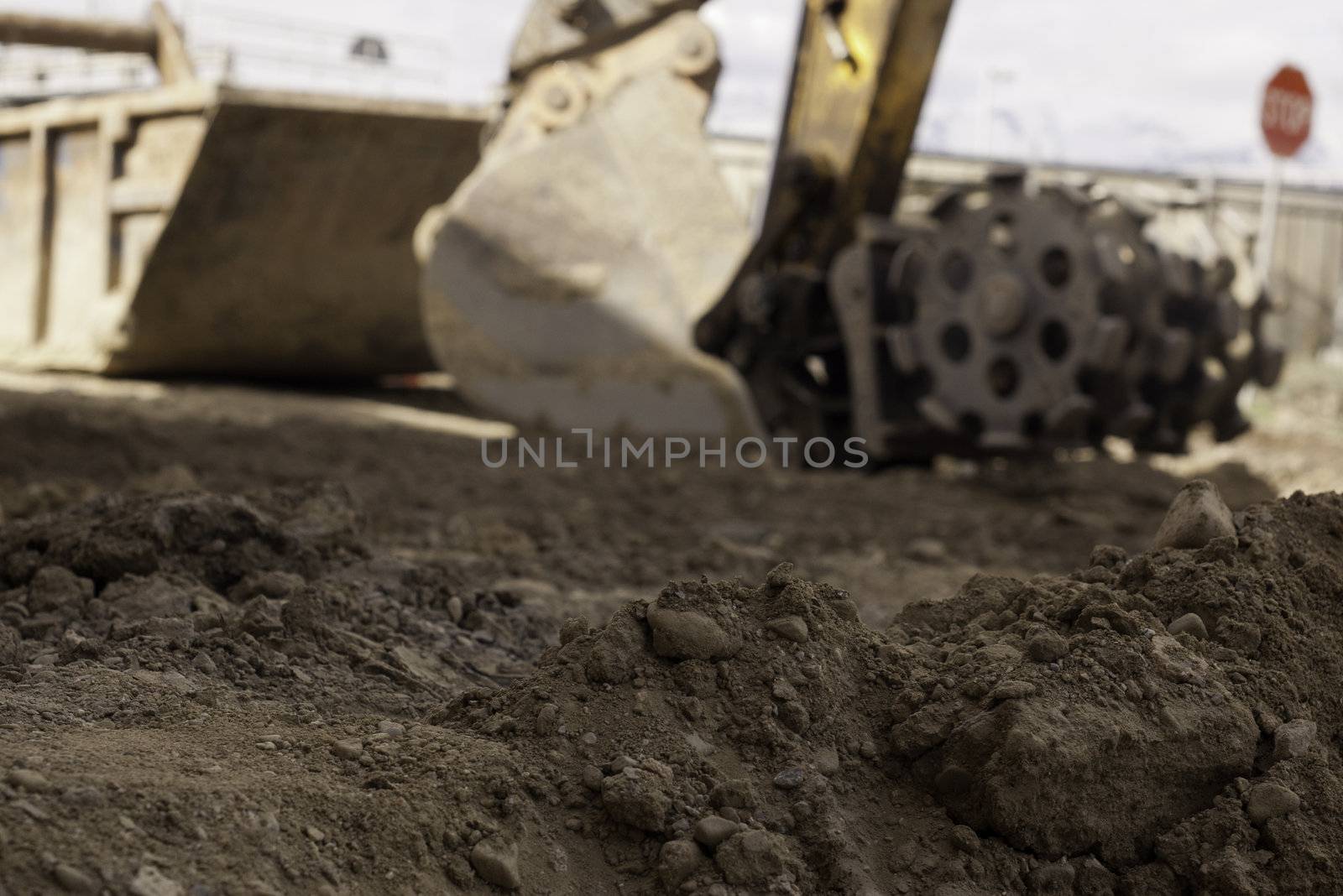dirt, soil, construction equipment in background