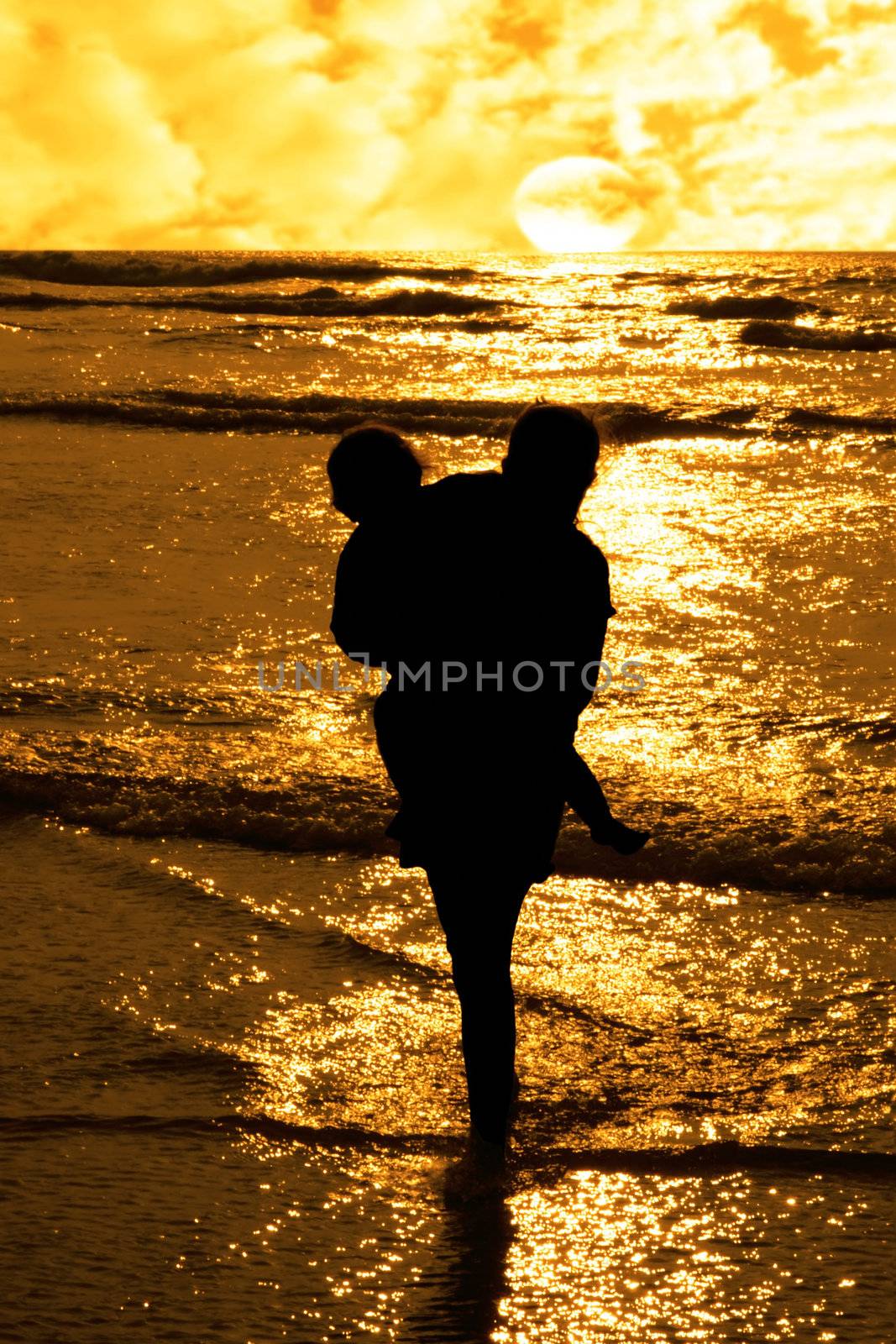 two girls in silhouette against a golden sunset one holding up the over with affection