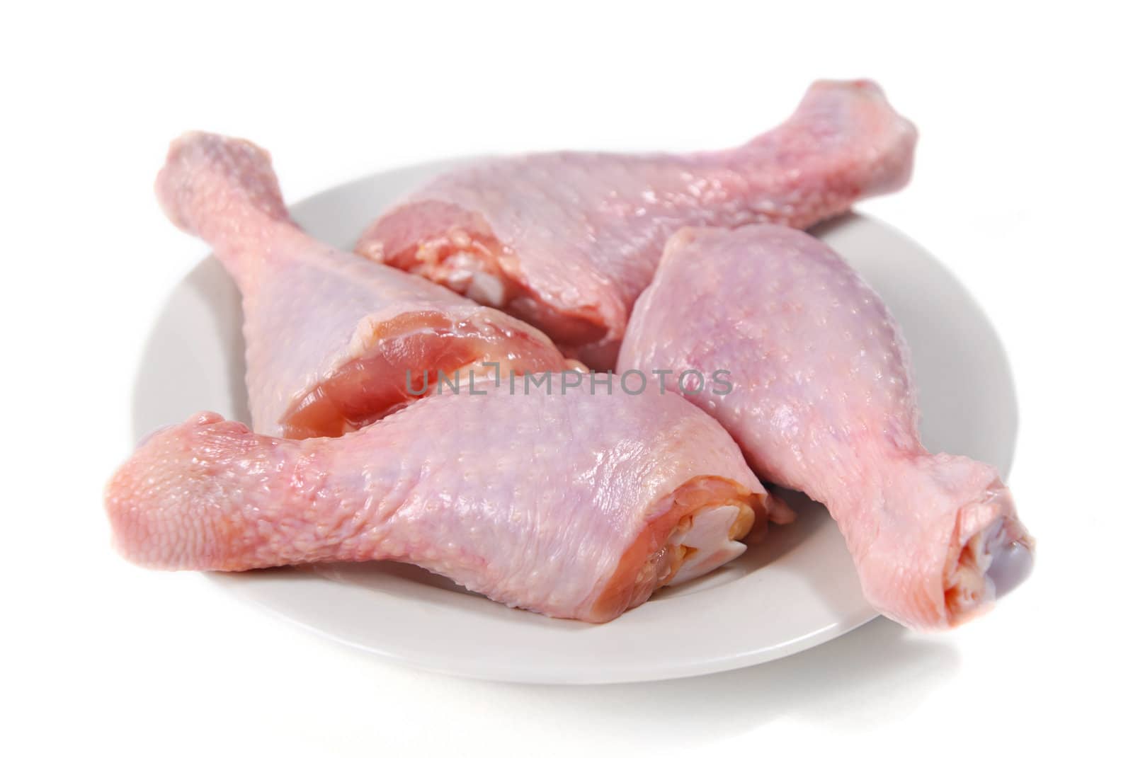 Four fresh raw chicken legs by firewings