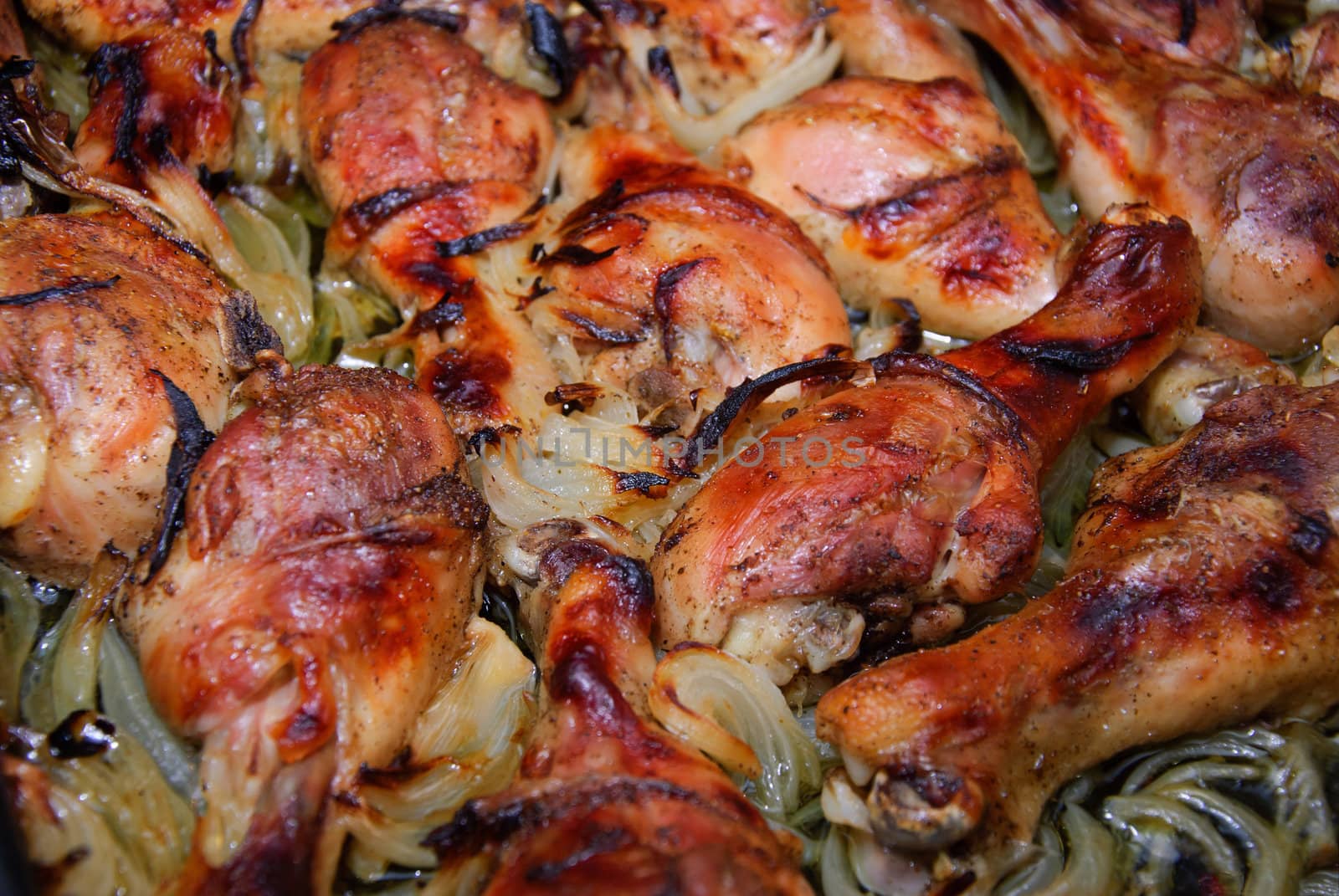 Fresh ripe roasted chicken legs on barbecue pan 