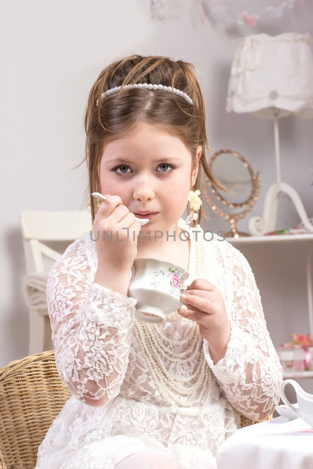 A beautiful little girl having a tea party