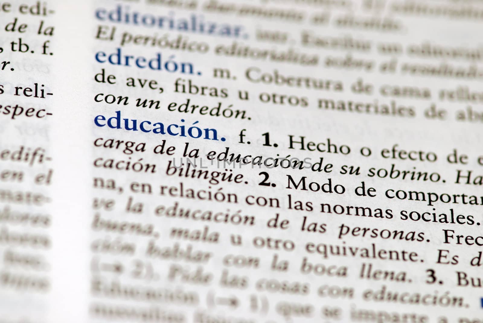 Spanish dictionary definition of the word education with focus on education and a hallow field depth.