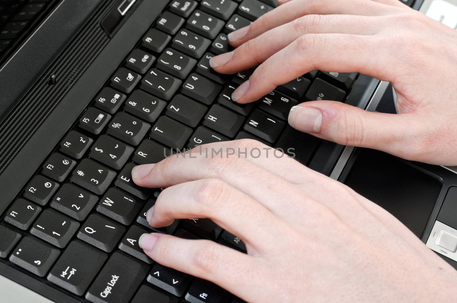 woman pressing keys on the laptop computer keyboard