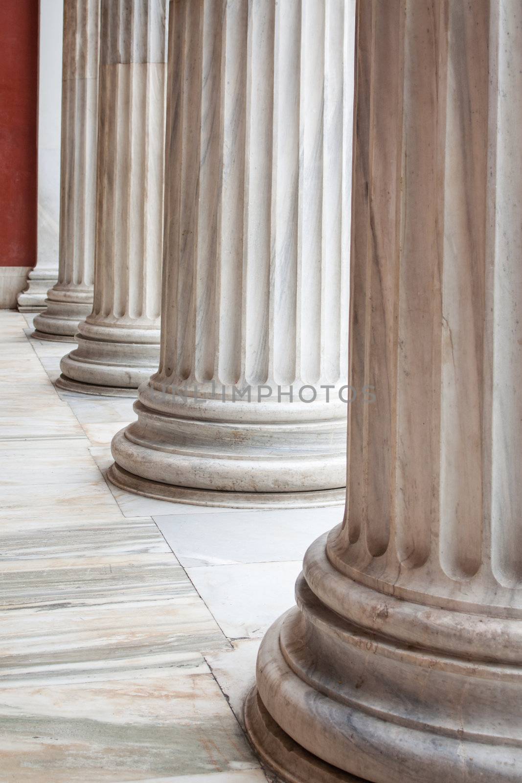 Closeup of row of neoclassical Greek columns in the porch of the archaeological museum of Athens, Greece.