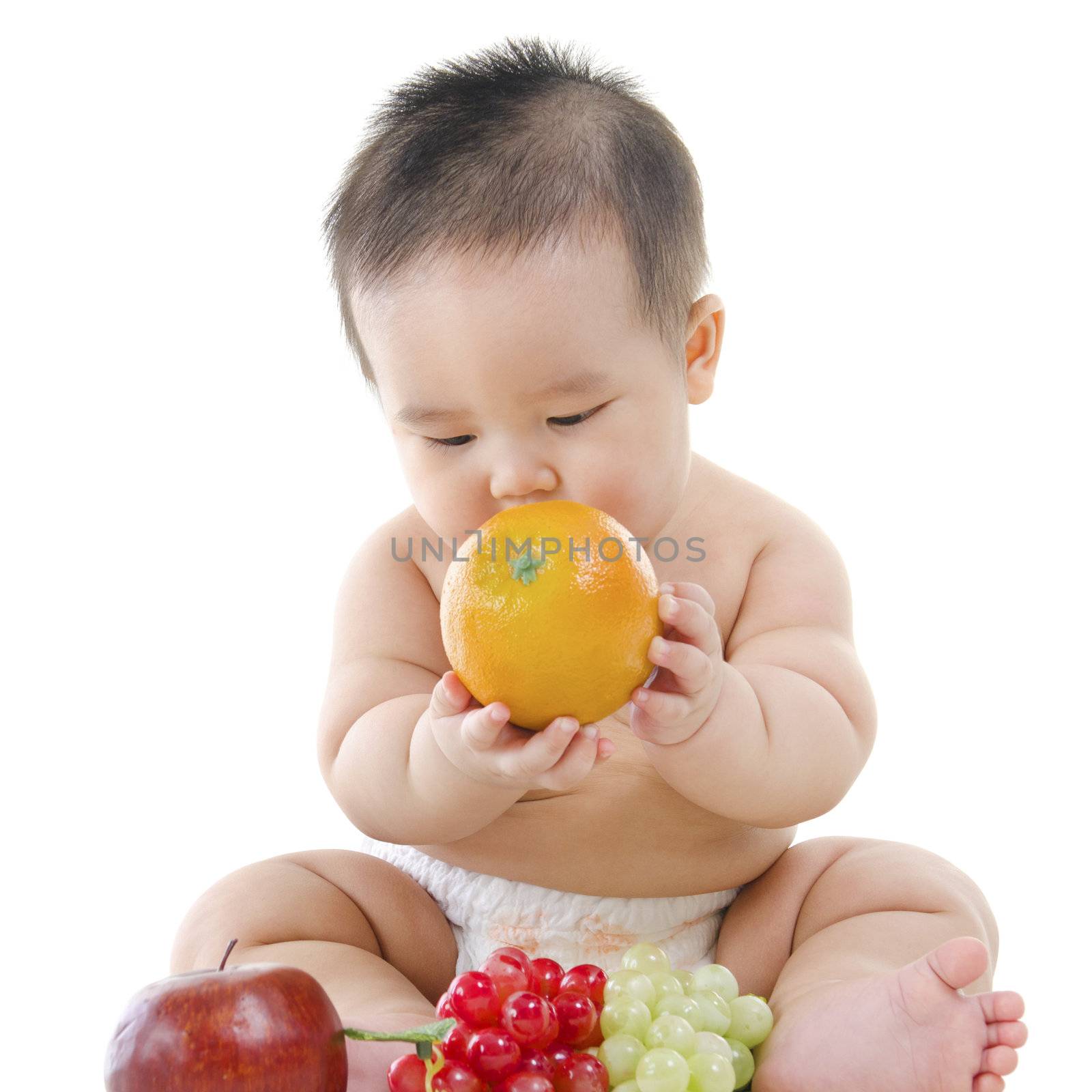 Pan Asian Vegetarian baby playing with fruits on white background
