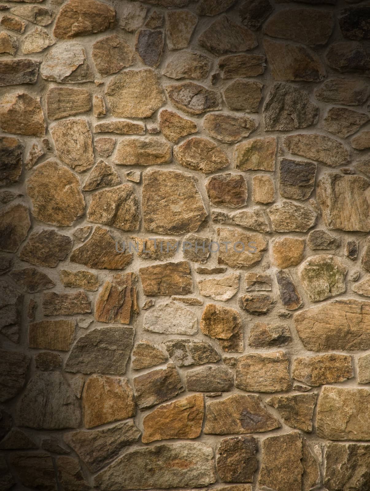 Brown masonry rock wall lit diagonally