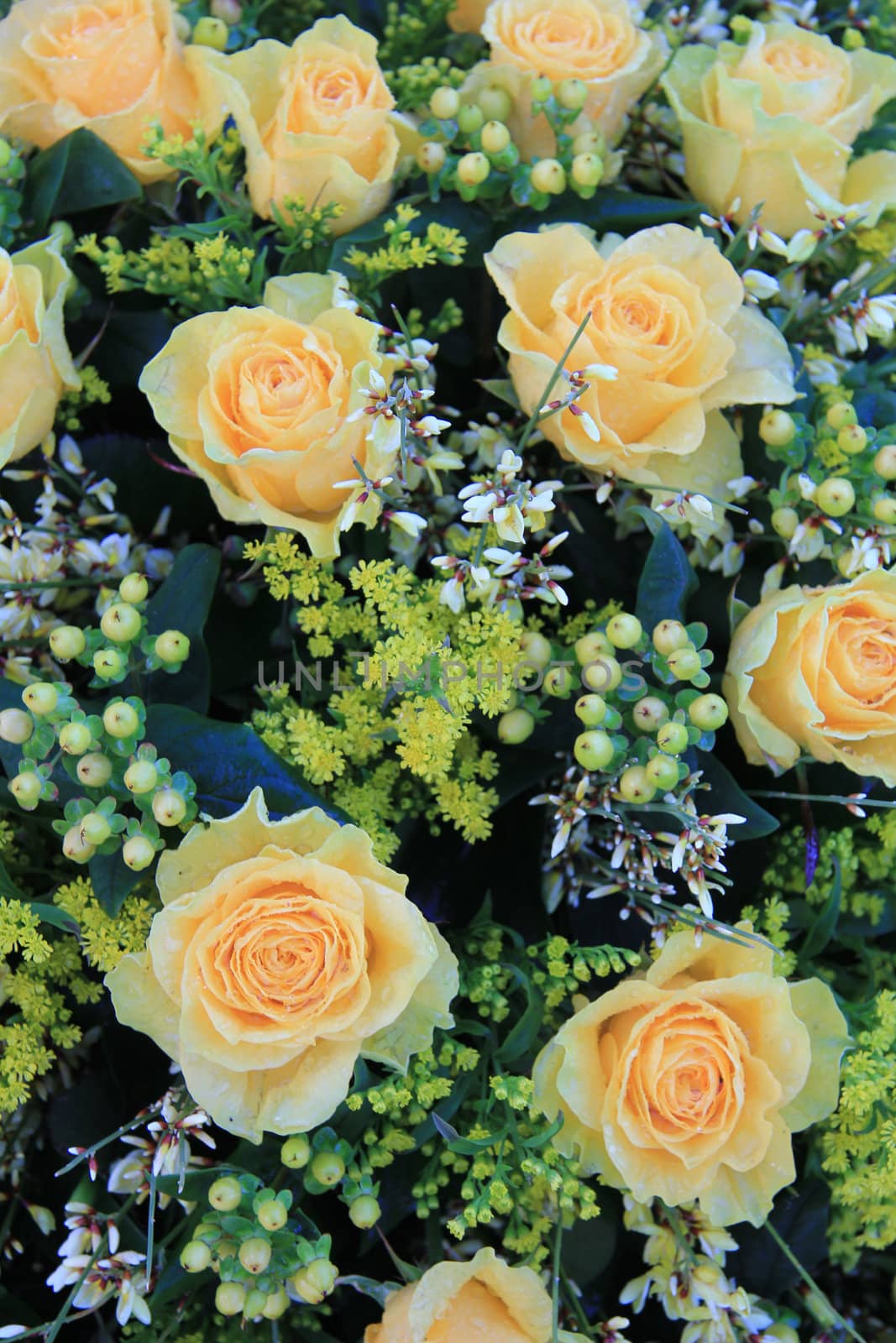 a bouquet with pale yellow roses and some green decorations