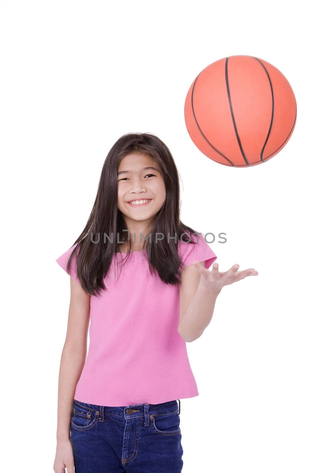 Ten year old Asian girl throwing basketball up into air, isolated on white