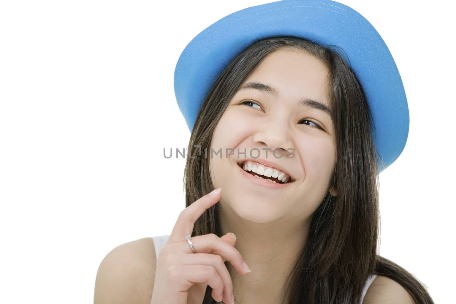 Beautiful young teen girl in blue hat, looking up with thoughtful expression, as if she has a fun idea or thought. Isolated on white