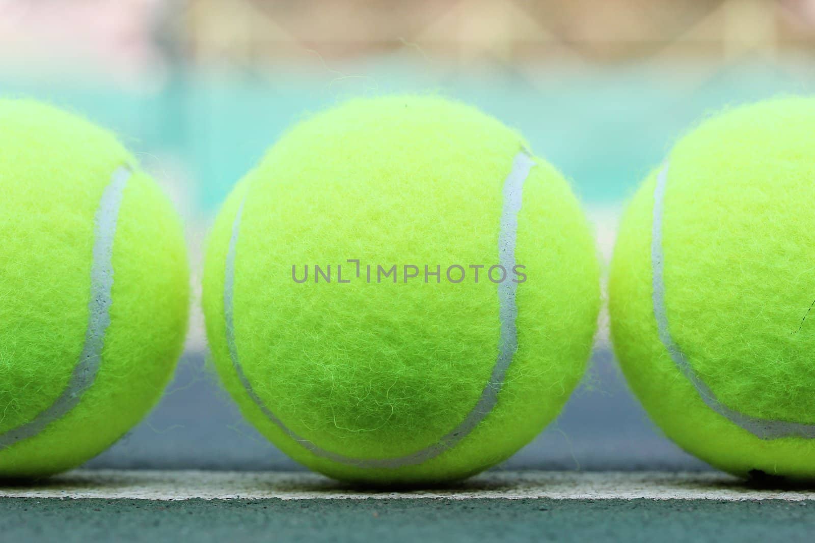 Brand new tennis balls arranged in a row by mnsanthoshkumar