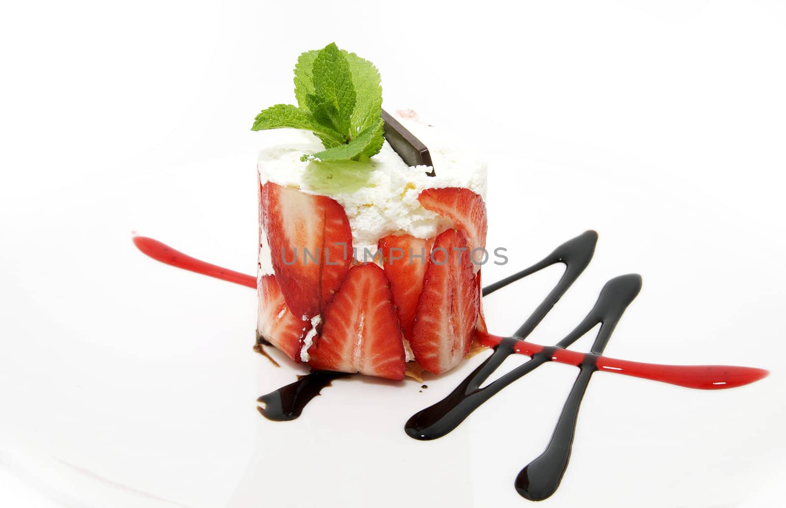 Strawberry dessert decorated with mint and chocolate cream
