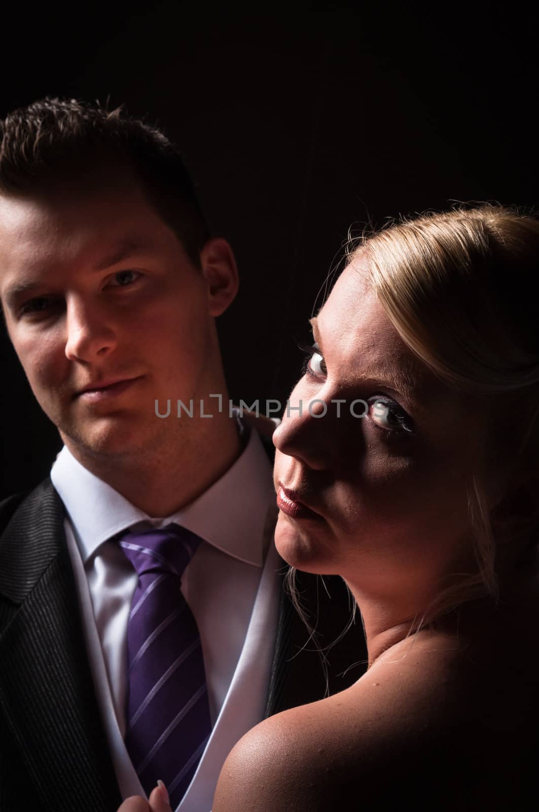 Groom and bride against dark background