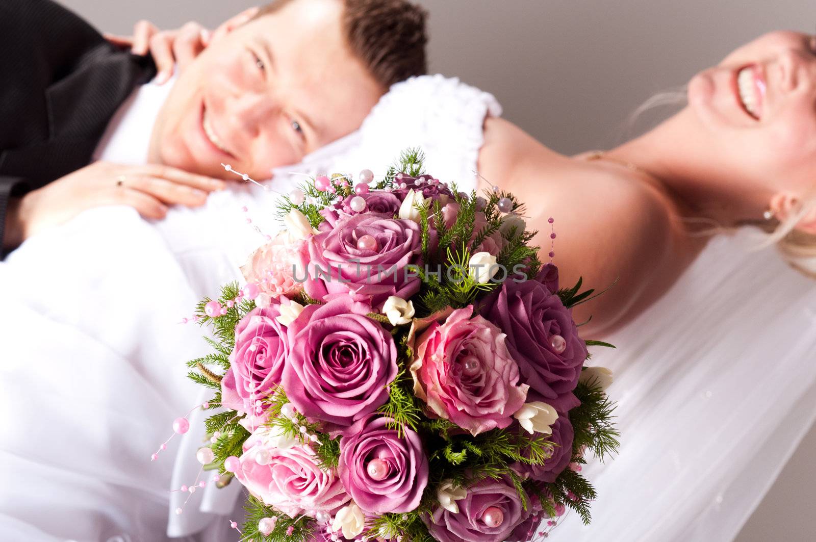 young couple in wedding wear with bouquet of roses by svedoliver
