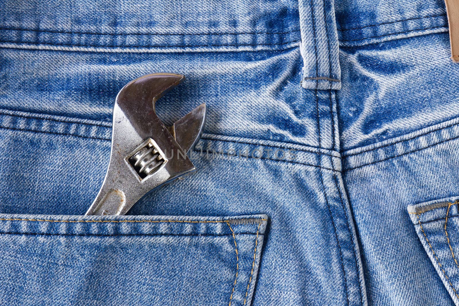 Blue jeans pocket with old tool