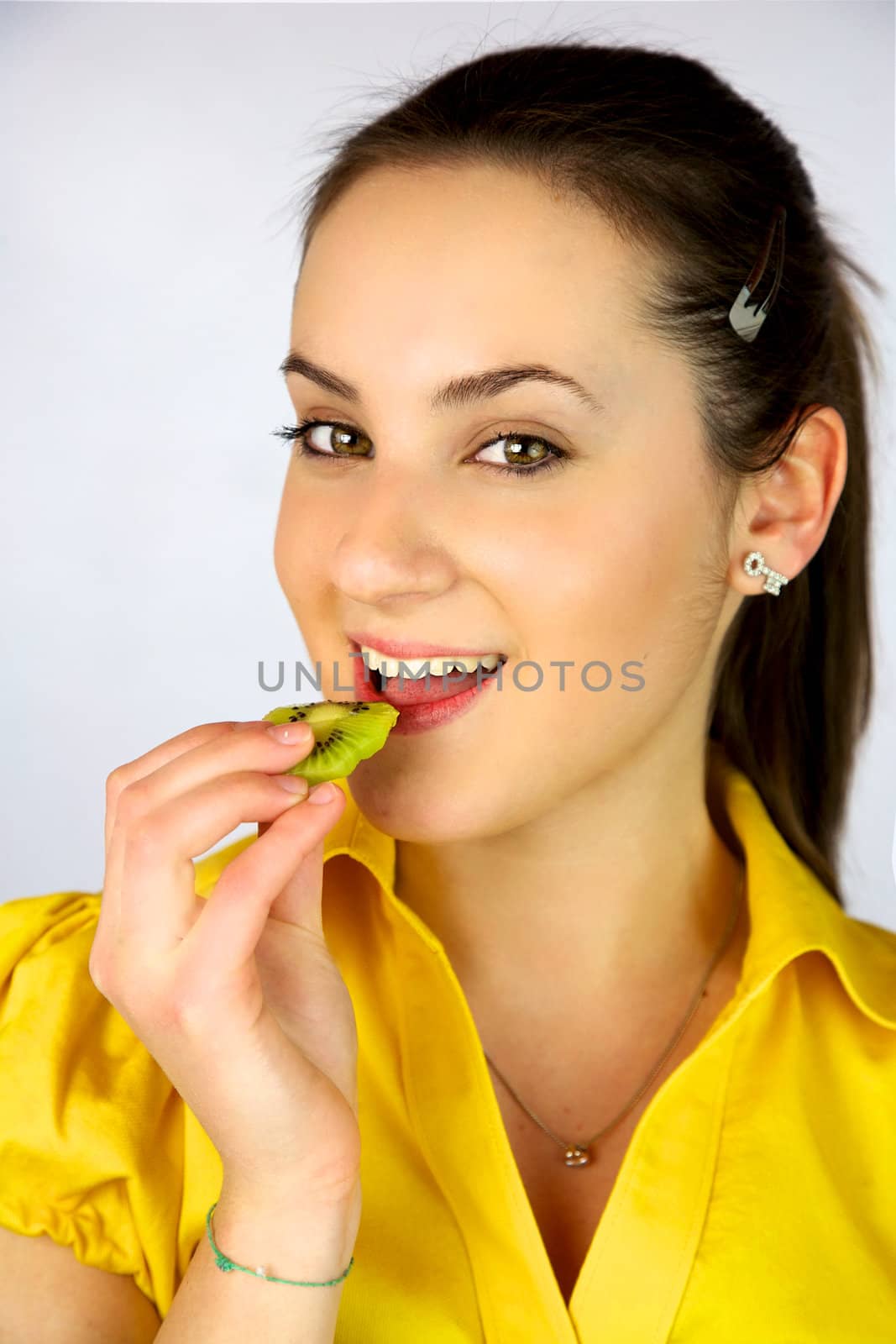 Beautiful girl eating fresh kiwi smiling happy by fmarsicano
