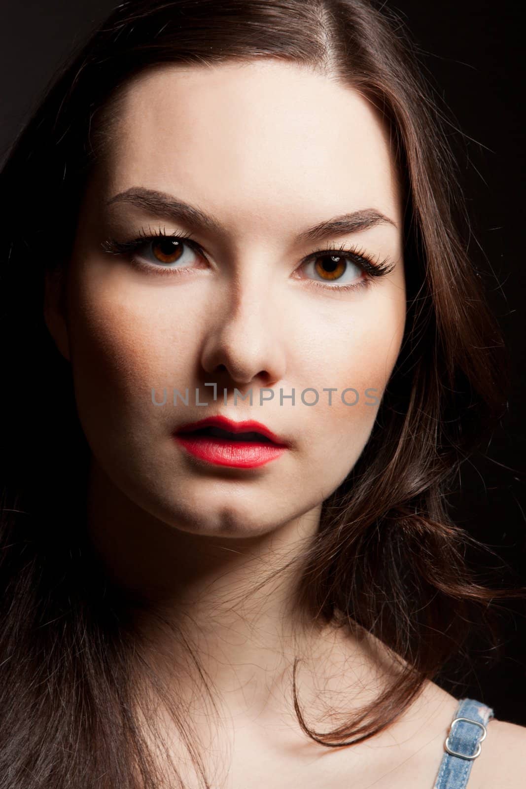 The portrait of sensual young woman on dark background