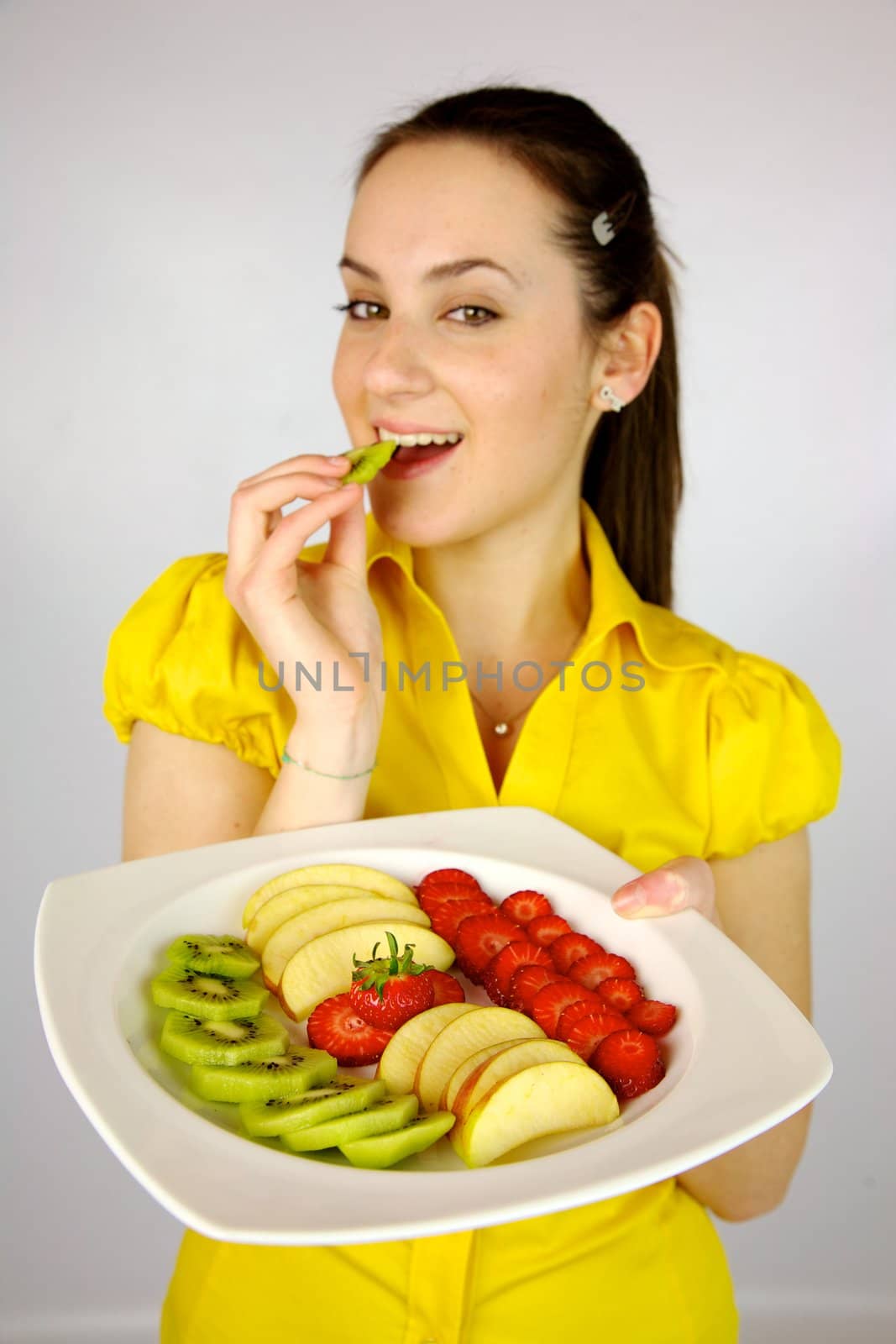 gorgeous brunette female model with plate full of fruit