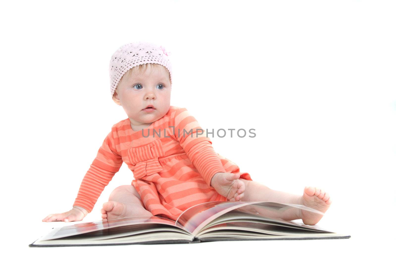 The little blue-eyed girl thumbs through the book. A portrait on a white background. Option 3