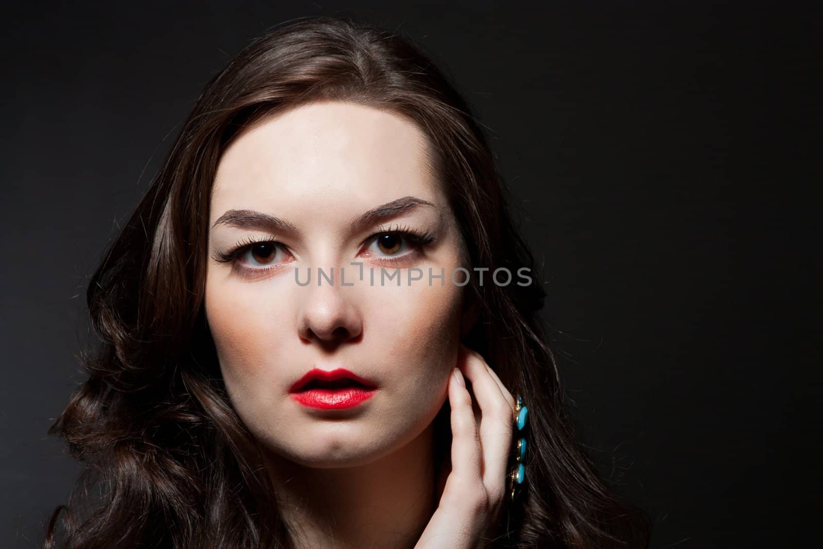 The portrait of sensual young woman on dark background