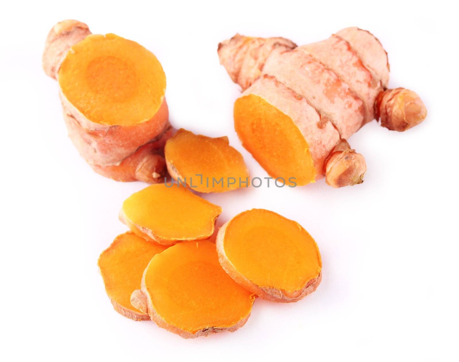 Fresh indian medicinal spice turmeric or longa sliced and displayed on white.