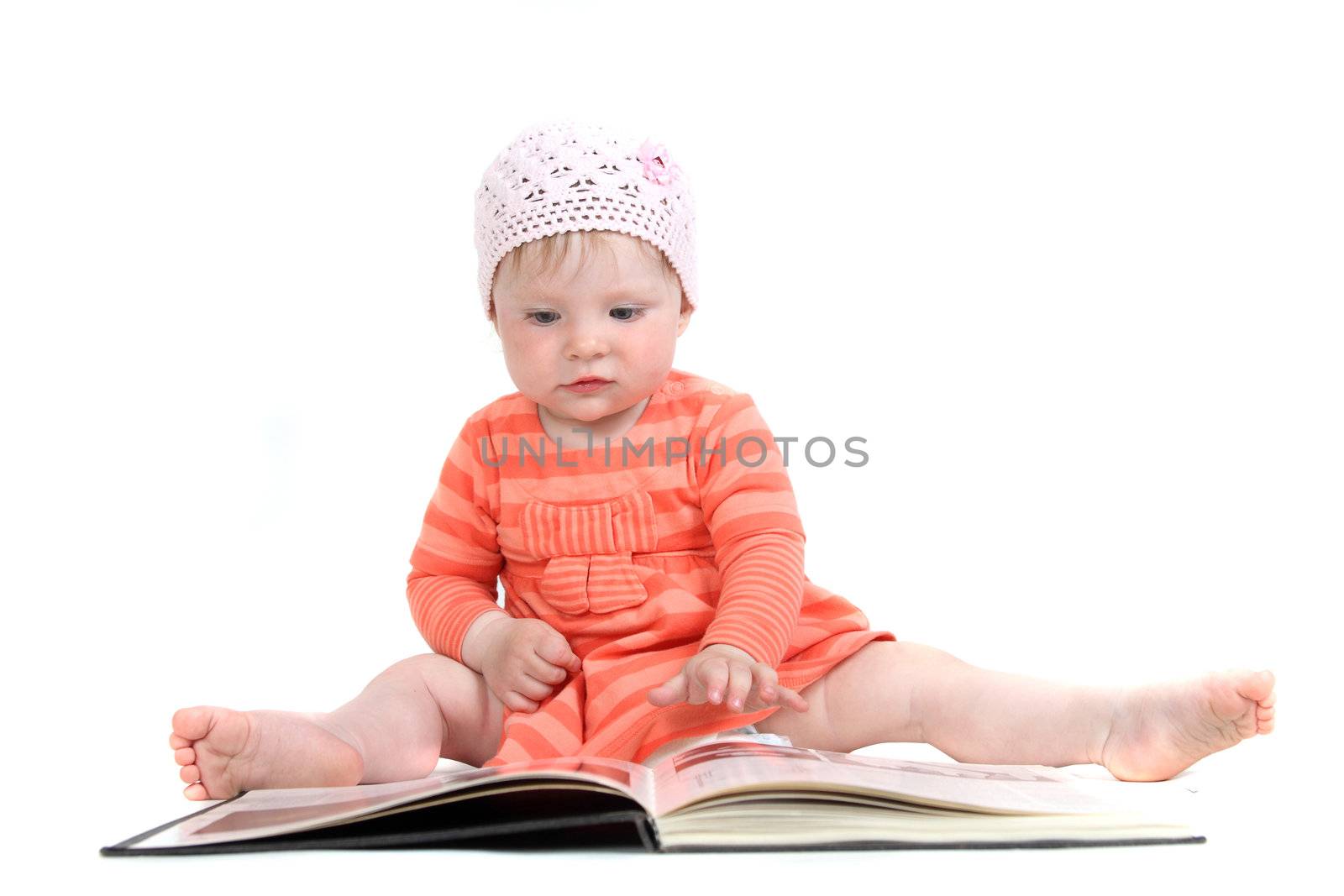 The little blue-eyed girl thumbs through the book. A portrait on a white background. Option 5