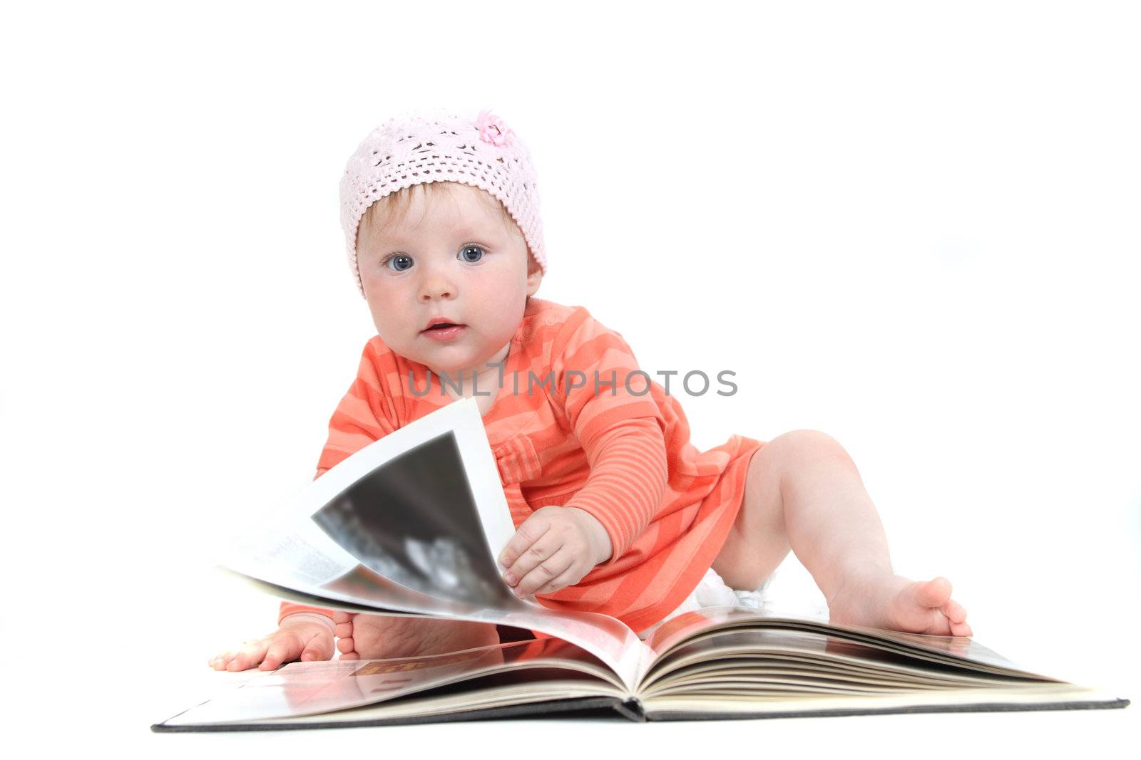 The little blue-eyed girl thumbs through the book. A portrait on a white background. Option 10