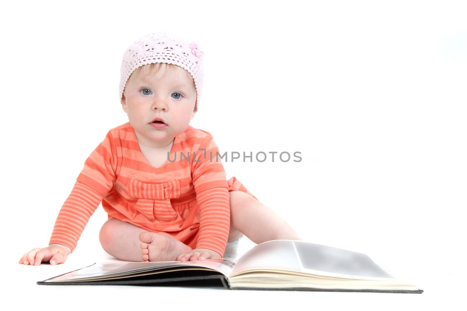 The little blue-eyed girl thumbs through the book. A portrait on a white background. Option 6