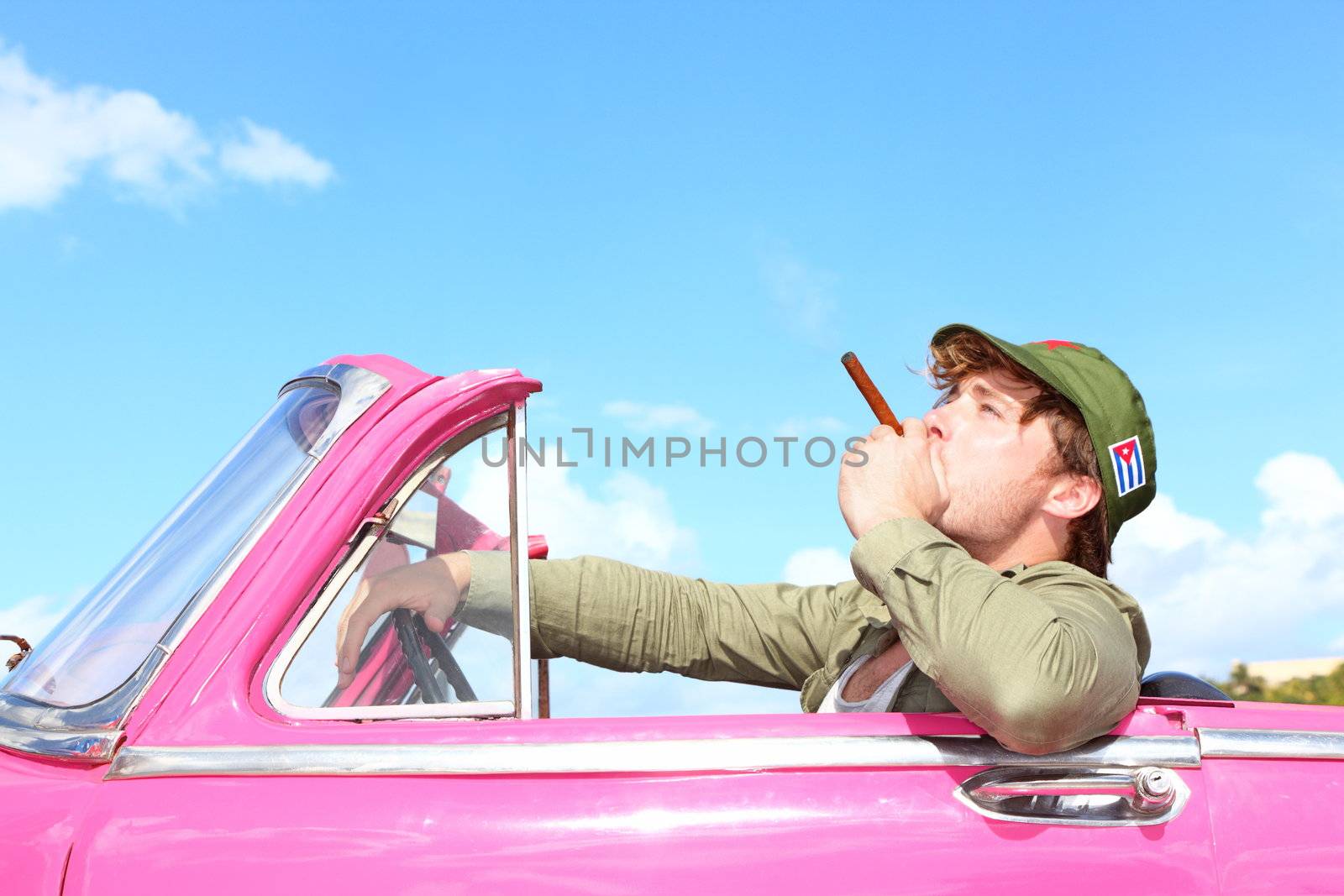 Cuba concept. Vintage car with cigar smoking man with Fidel Castro patrol cap. Funny image cuban conceptual image.
