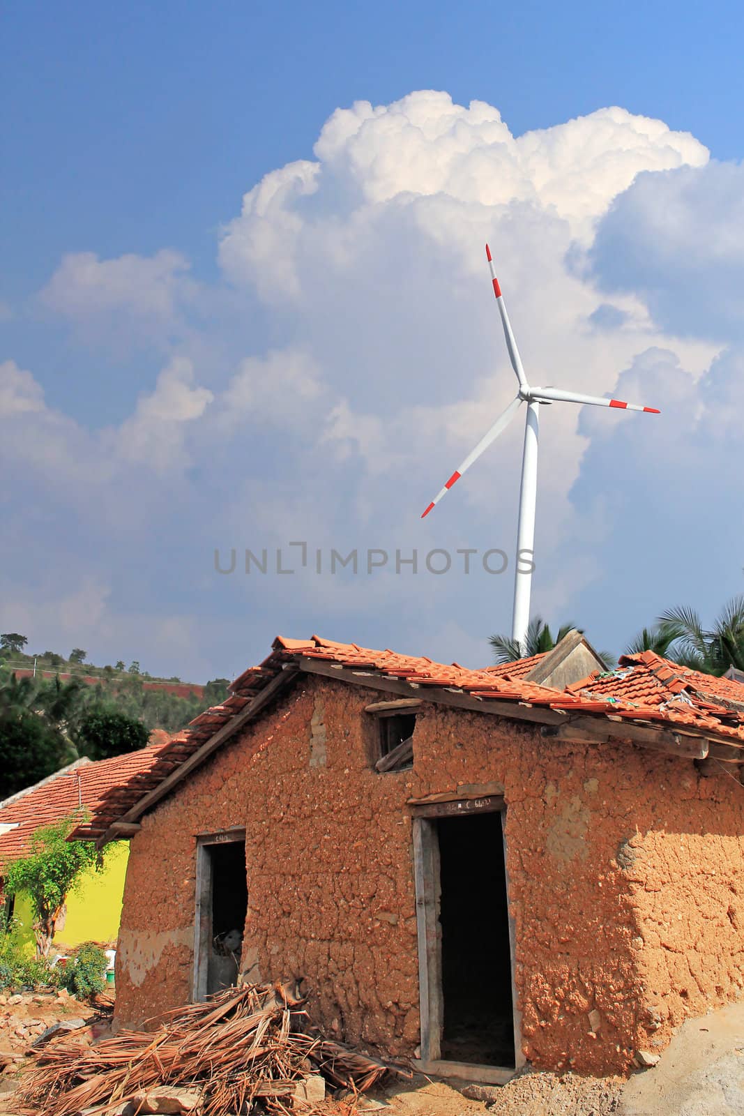 Old mud house in rural india with wind mill in the backdrop