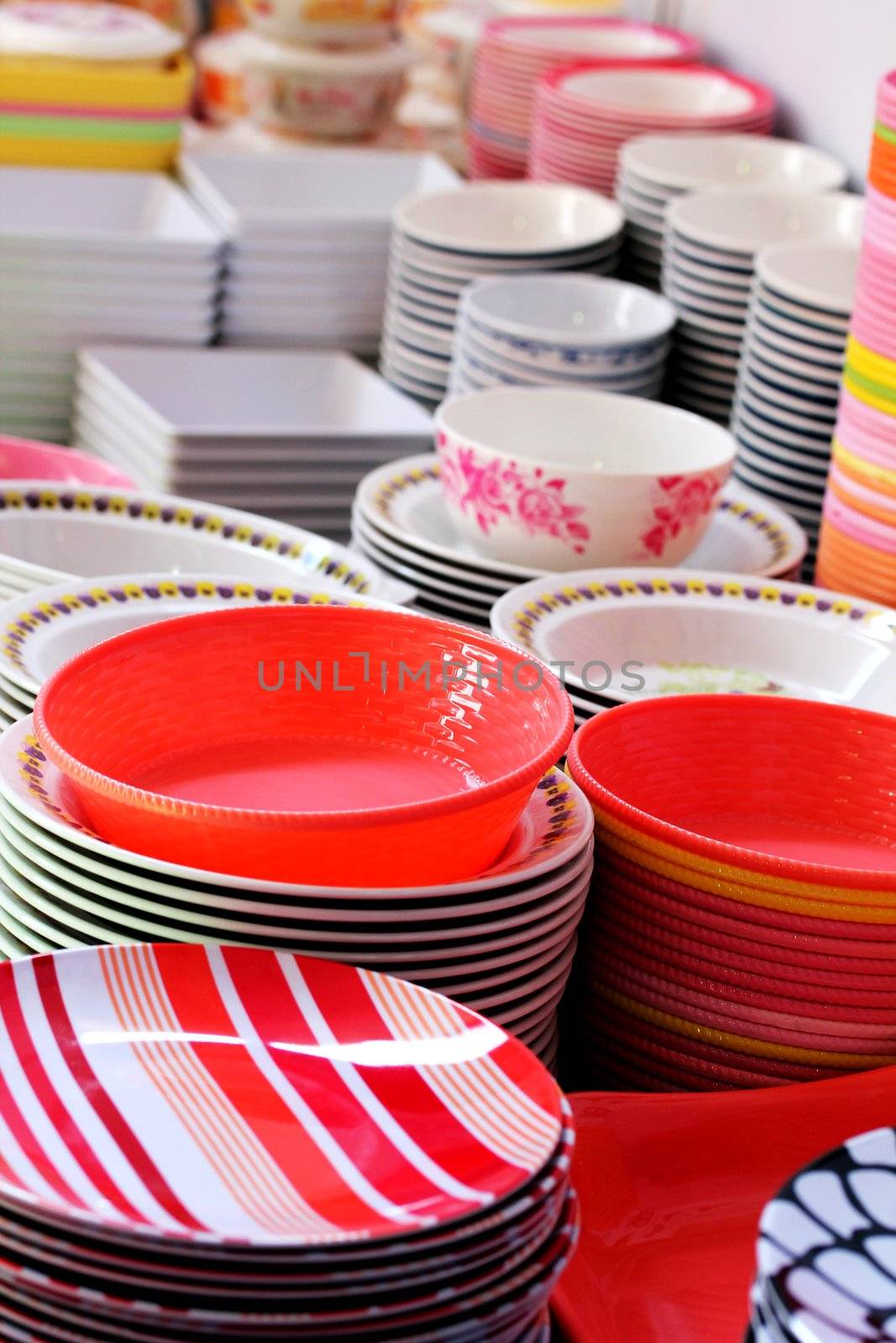 Colorful melamine, ceramic, china clay and plastic bowls arranged for sale in a market