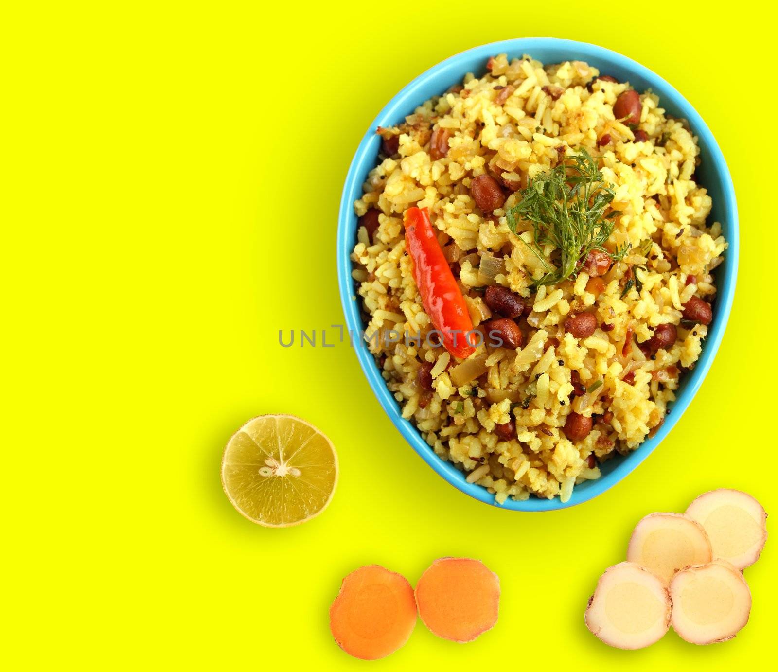 Spicy south indian breakfast called chitranna or poha with its ingredients - lemon, ginger and fresh turmeric.