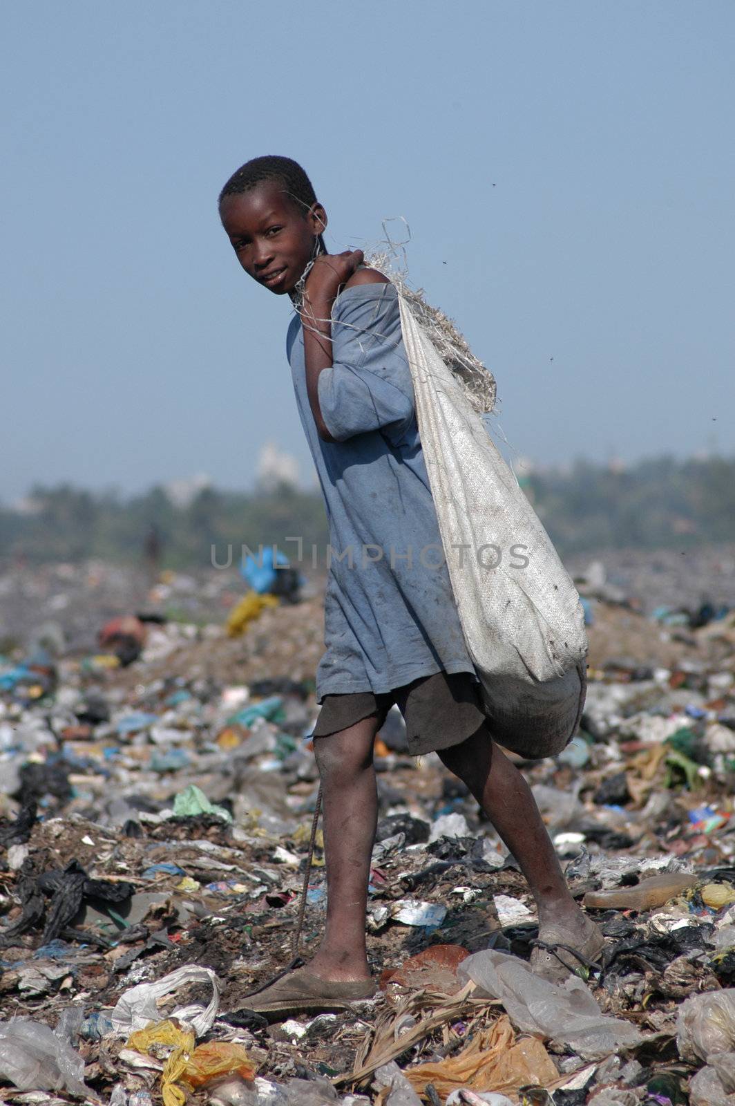 Maputo, Mozambique - May 14, 2004: a poor child in the landfill capital of Maputo in Mozambique. There are many street children in the garbage looking for food, bottles, Latin iron to resell