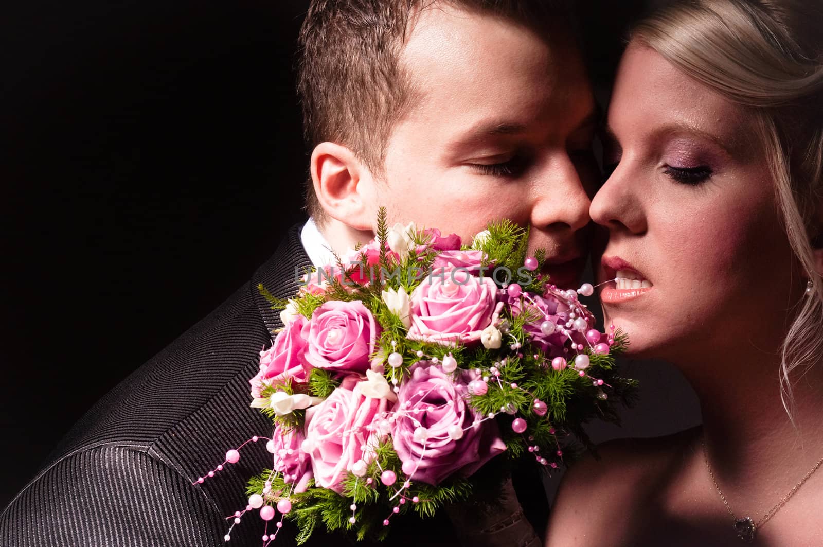 young couple in wedding wear with bouquet of roses by svedoliver